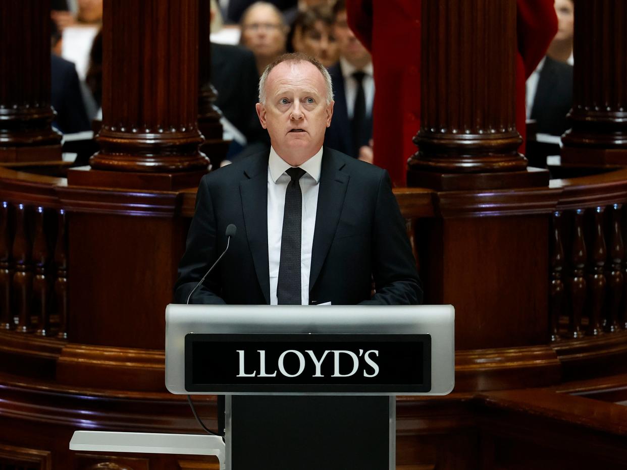 Lloyd's of London CEO John Neal behind a stand with a Lloyd's sign