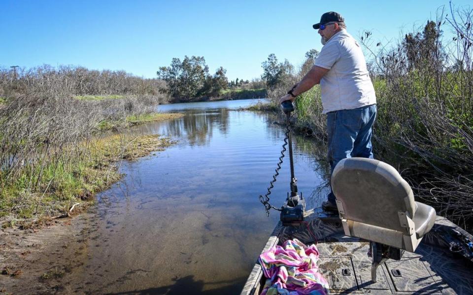 Fishing guide Louis Moosios navigates his boat through a shallow channel off the San Joaquin River before entering the Milburn Pond north of Fresno on Thursday, March 14, 2024.