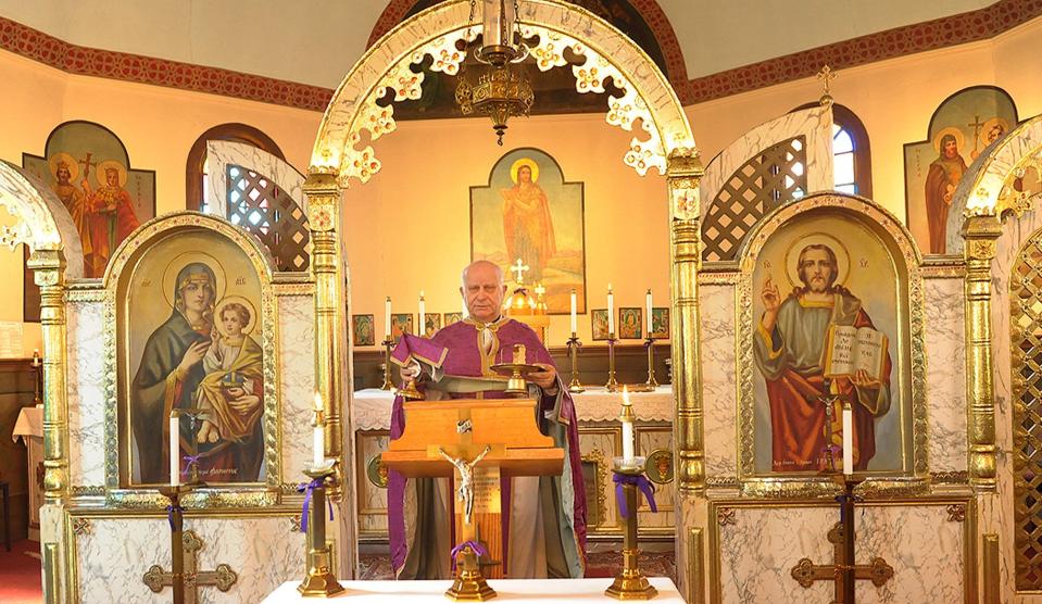 The Rev. Msgr. Roman Golemba presents the sacraments as he celebrates Mass in the ornate surroundings of St. John the Baptist Ukrainian Catholic Church in 2014. For most of the service, Golemba is through the gate, seen behind him in this photo, and facing the altar.