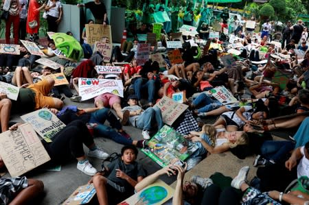 Environmental activist play dead as they participate in a Global Climate Strike near the Ministry of Natural Resources and Environment office in Bangkok