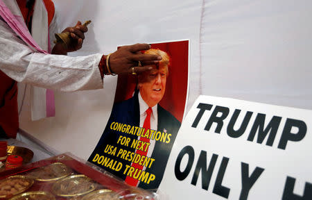 A member of Hindu Sena, a right-wing Hindu group, applies a spiritual mark "tilak' on a poster of U.S. Republican presidential nominee Donald Trump as they symbolically celebrate his victory in the upcoming U.S. elections, in New Delhi, India, November 4, 2016. REUTERS/Adnan Abidi