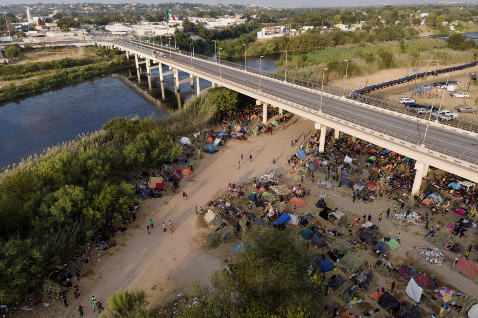 Migrants, many from Haiti, are seen at an encampment along the Del Rio International Bridge near the Rio Grande, Tuesday, Sept. 21, 2021, in Del Rio, Texas. The options remaining for thousands of Haitian migrants straddling the Mexico-Texas border are narrowing as the United States government ramps up to an expected six expulsion flights to Haiti and Mexico began busing some away from the border. (AP Photo/Julio Cortez)