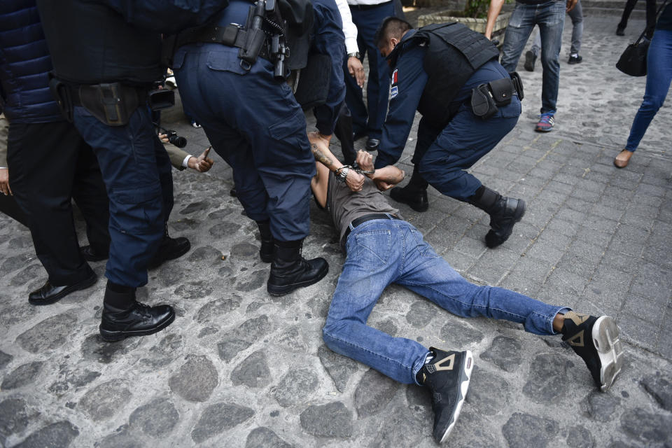 Police arrest a man who started shooting outside city hall in Cuernavaca, Mexico, Wednesday, May 8, 2019. A union official accompanying protesting street vendors and another trade unionist died during the shooting, while a TV cameraman and another person were wounded, according to officials (AP Photo/Tony Rivera)