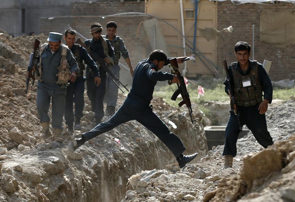 Afghan policemen arrive at the site of an attack, near a building north of Kabul International Airport in Kabul