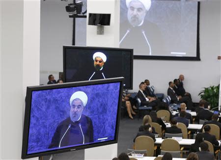 Iran's President Hassan Rouhani is shown on video monitors as he addresses the 68th United Nations General Assembly at UN headquarters in New York, September 24, 2013. REUTERS/Ray Stubblebine