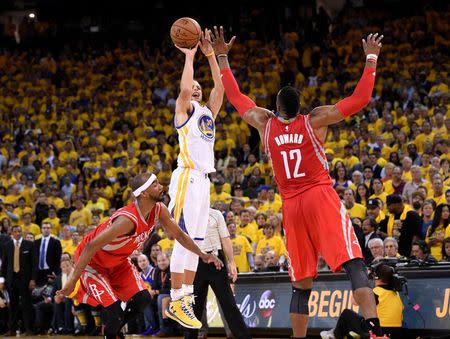 May 27, 2015; Oakland, CA, USA; Golden State Warriors guard Stephen Curry (30) shoots over Houston Rockets center Dwight Howard (12) during the fourth quarter in game five of the Western Conference Finals of the NBA Playoffs. at Oracle Arena. Kyle Terada-USA TODAY Sports