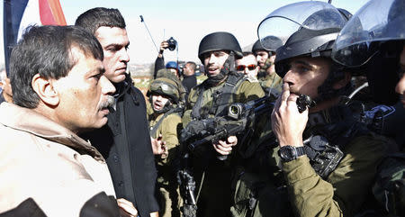 Palestinian minister Ziad Abu Ein (L) argues with Israeli soldiers during a protest near the West Bank city of Ramallah December 10, 2014. REUTERS/Mohamad Torokman