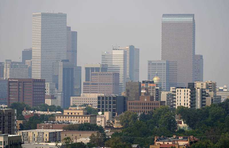 Smoke envelopes the downtown skyline as winds carry the smoky air from the Cameron Peaks wildland fire burning in Colorado's High Country.