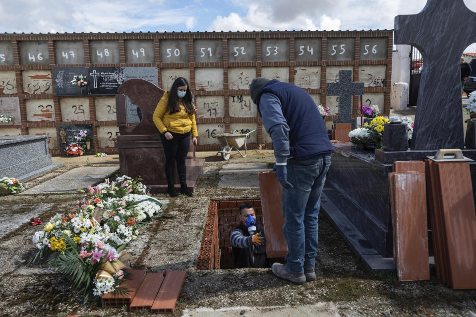 An undertaker prepares a grave during the burial of Rosalia Mascaraque, 86, during the coronavirus outbreak in Zarza de Tajo, central Spain, Wednesday, April 1, 2020. Intensive care units are particularly crucial in a pandemic in which tens of thousands of patients descend into acute respiratory distress. The new coronavirus causes mild or moderate symptoms for most people, but for some, especially older adults and people with existing health problems, it can cause more severe illness or death. (AP Photo/Bernat Armangue)