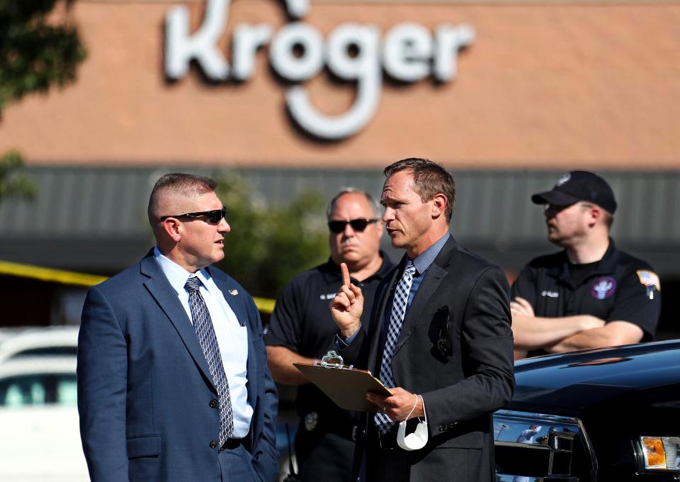 Law enforcement officers confer at the scene following the shooting (AP)