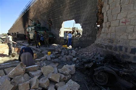 Workers rebuild the main prison wall after an explosion outside the central prison in Sanaa, in this February 14, 2014 file photo. REUTERS/Mohamed al-Sayaghi/Files