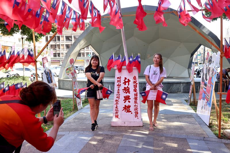 People take photos with Taiwanese flags at the park decorated by Chang Lao-wang ahead of Taiwan National Day in Taoyuan