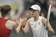 Poland's Iga Swiatek, right, is congratulated by Switzerland's Simona Waltert after their Billie Jean King Cup qualification round tennis match at the Jan Group Arena in Biel, Switzerland, Friday, April 12, 2024. (Peter Schneider/Keystone via AP)