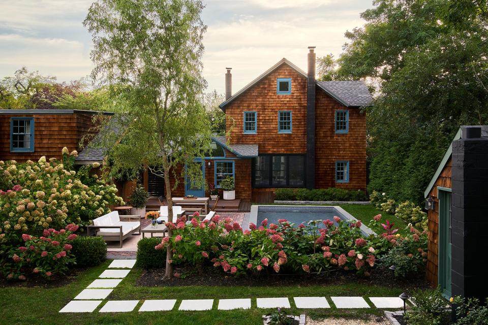 Exterior of home with cedar shake siding and a pool