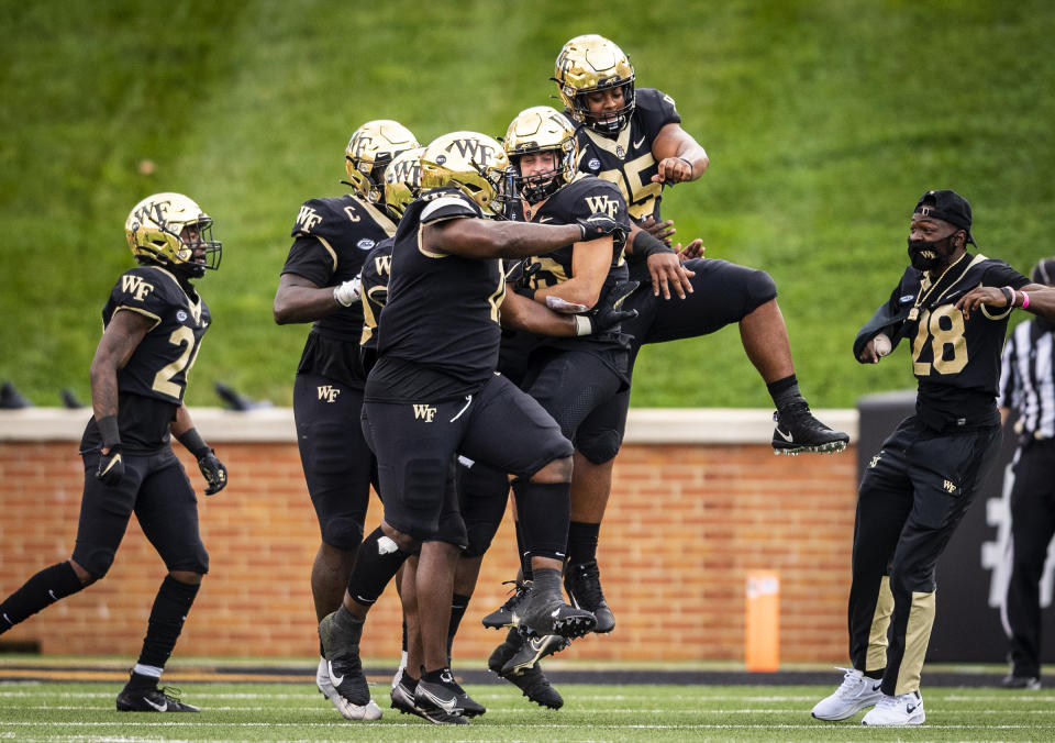 Wake Forest defensive back Nick Andersen (45) is congratulated by teammates after intercepting a pass in the end zone on the last play of the first half of an NCAA college football game against Virginia Tech, Saturday, Oct. 24, 2020, in Winston-Salem, N.C. (Andrew Dye/The Winston-Salem Journal via AP)