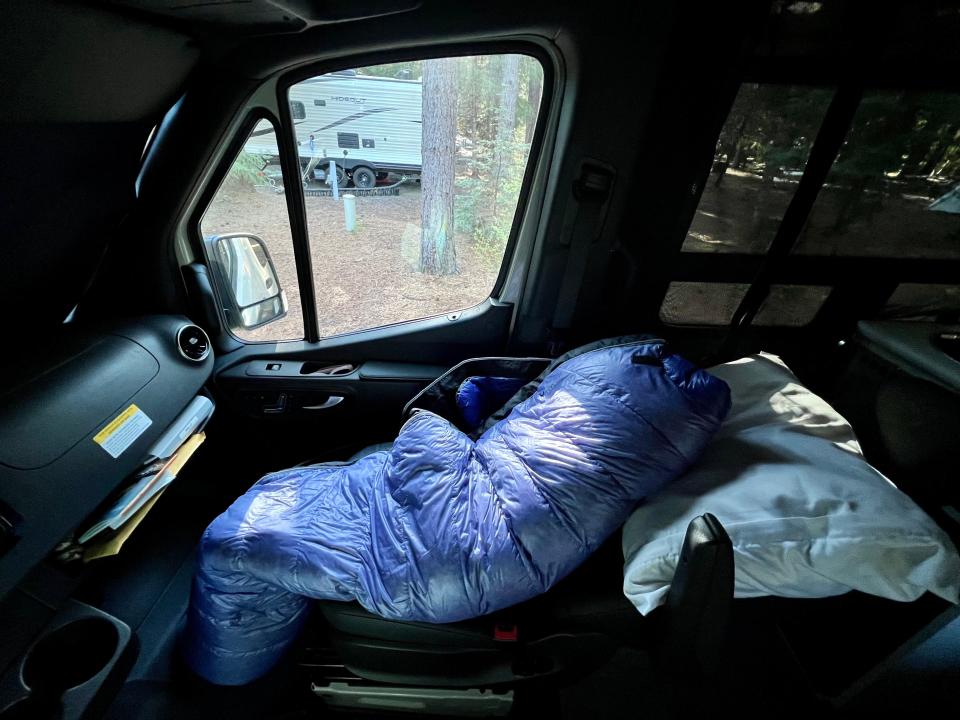 sleeping bag and pillow in front seat of camper van