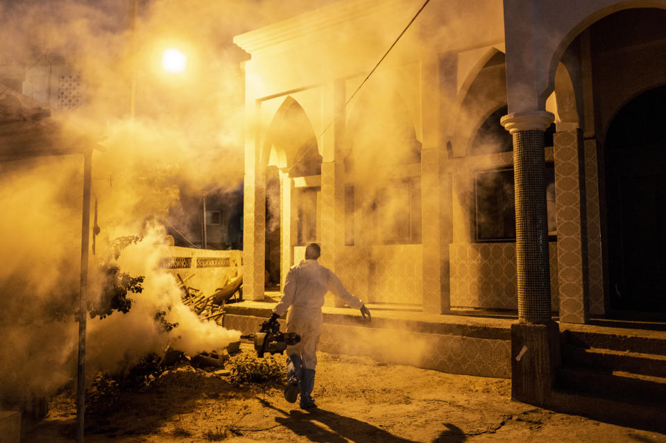 In this Wednesday, April 1, 2020, photo, a municipal worker sprays disinfectant in a mosque to help curb the spread of the new coronavirus in Dakar, Senegal. The new coronavirus causes mild or moderate symptoms for most people, but for some, especially older adults and people with existing health problems, it can cause more severe illness or death. (AP Photo/Sylvain Cherkaoui)