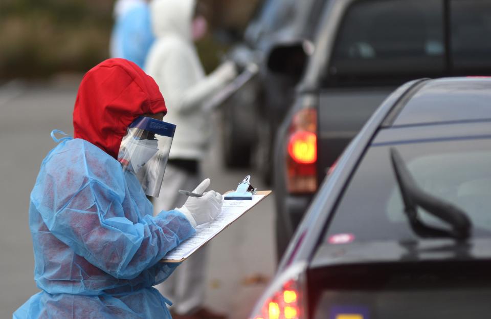 Passion Windham, a COVID-19 investigator and screener with the New Hanover County Health Department in Wilmington, N.C., asks questions before conducting a coronavirus test during a community outreach event on Dec. 14.