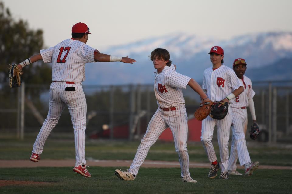 Oak Hills' Austin Allan celebrates with Tyler Martinez after striking out Apple Valley’s Isaiah Reveron with the bases loaded in the top of the seventh inning on Friday, March 8, 2024. Oak Hills defeated Apple Valley 5-3 in the Mojave River League opener.