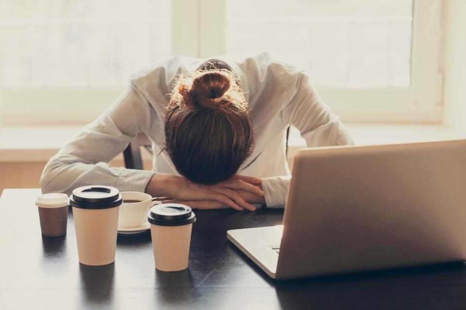 Tired woman with empty coffee cups