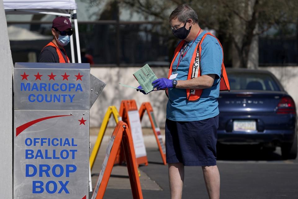 FILE - In this Tuesday, Oct. 20, 2020 file photo, volunteers help voters as voters drop off their ballots at the Maricopa County Recorder's Office in Phoenix. An Associated Press investigation has found county election officials throughout Arizona have identified fewer than 200 cases of potential voter fraud from last year's presidential election that require review by local prosecutors. The findings undermine claims by former President Donald Trump and his allies that widespread fraud is to blame for his loss in Arizona. (AP Photo/Ross D. Franklin, File)