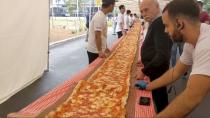 People look at a 100m long margherita pizza before it receives its final toppings as part of a charity event to raise funds for the New South Wales Rural Fire Service, in Sydney