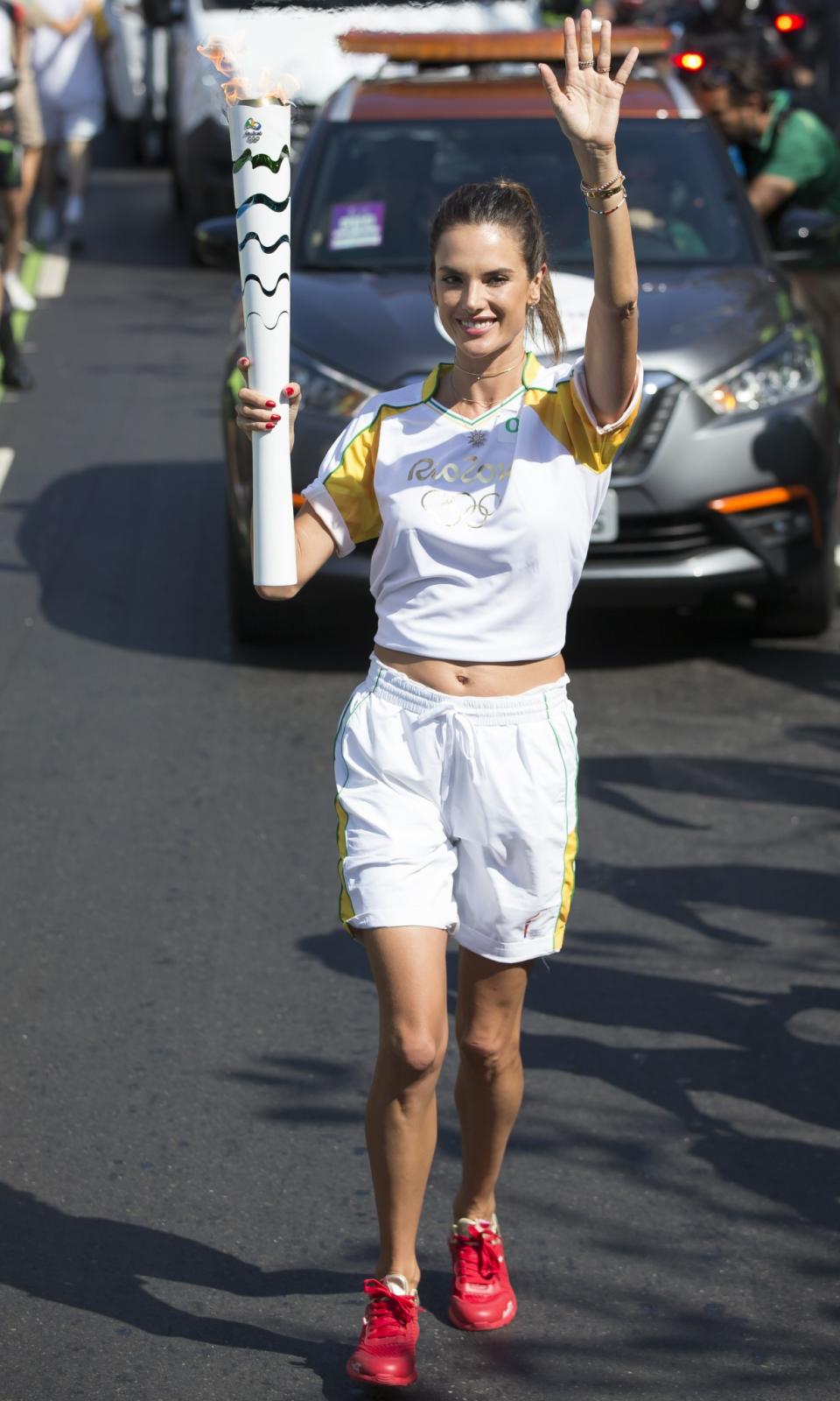 <p>Coca-Cola Torch Bearer Alessandra Ambrosio has the ultimate #ThatsGold moment as she runs with the Olympic flame through Rio de Janeiro on August 5, 2016 in Rio de Janeiro, Brazil. (Photo by Buda Mendes/Getty Images for Coca-Cola) </p>