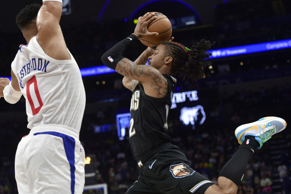 Memphis Grizzlies guard Ja Morant, right, shoots against Los Angeles Clippers guard Russell Westbrook (0) in the first half of an NBA basketball game Friday, March 31, 2023, in Memphis, Tenn. (AP Photo/Brandon Dill)