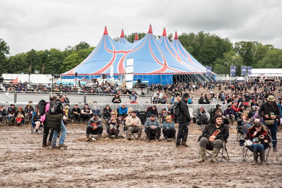 Donington, United Kingdom. 16th June 2024. Revellers sitting in sinking chairs at a muddy Download Festival. Credit: Cristina Massei/Alamy live news