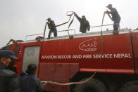 <p>Nepalese firemen work at the site after a passenger plane from Bangladesh crashed at the airport in Kathmandu, Nepal, March 12, 2018. (Photo: Niranjan Shreshta/AP) </p>