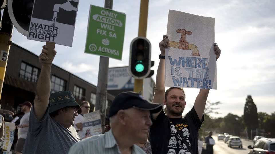 Residents hold placards during a protest against water shortages in the Blairgowrie area of Johannesburg on March 12, 2024. - Wikus de Wet/AFP/Getty Images