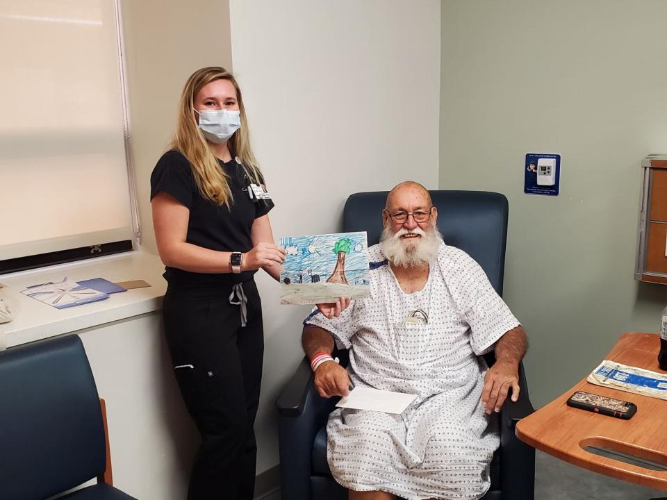 Registered Nurse Baleigh Roach stands with her patient, Herbert Linwood Oden Jr. after presenting him with a gift from a local elementary school student made to brighten Oden's day.