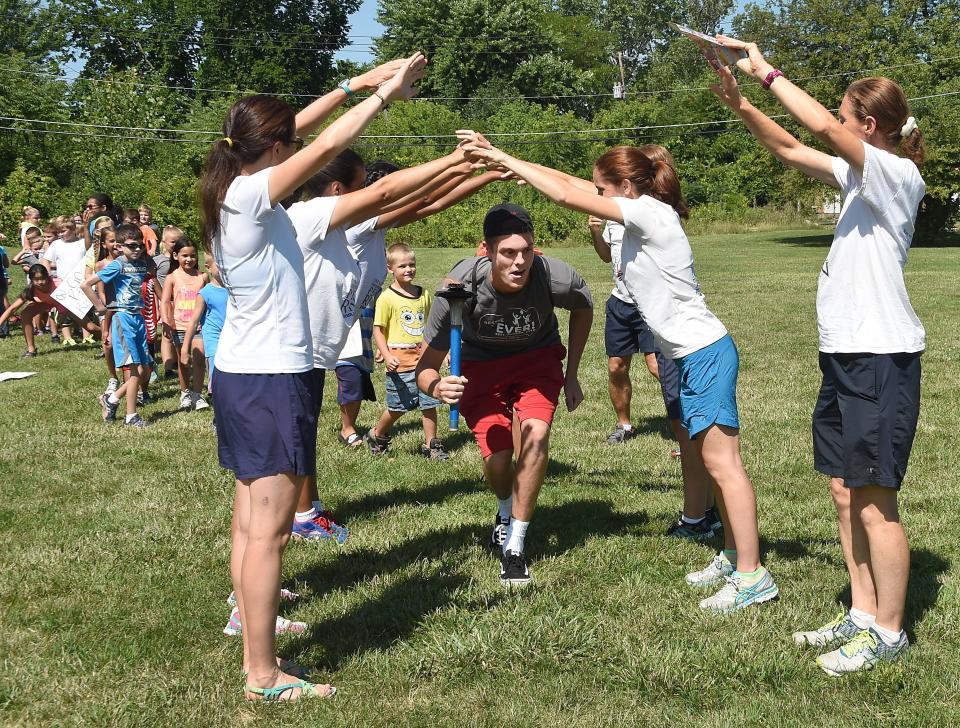 Torin Wetzel, summer camp counselor at the Monroe Family YMCA, leads a peace parade at a previous camp. This year's summer camp runs June 17 through Aug. 23.