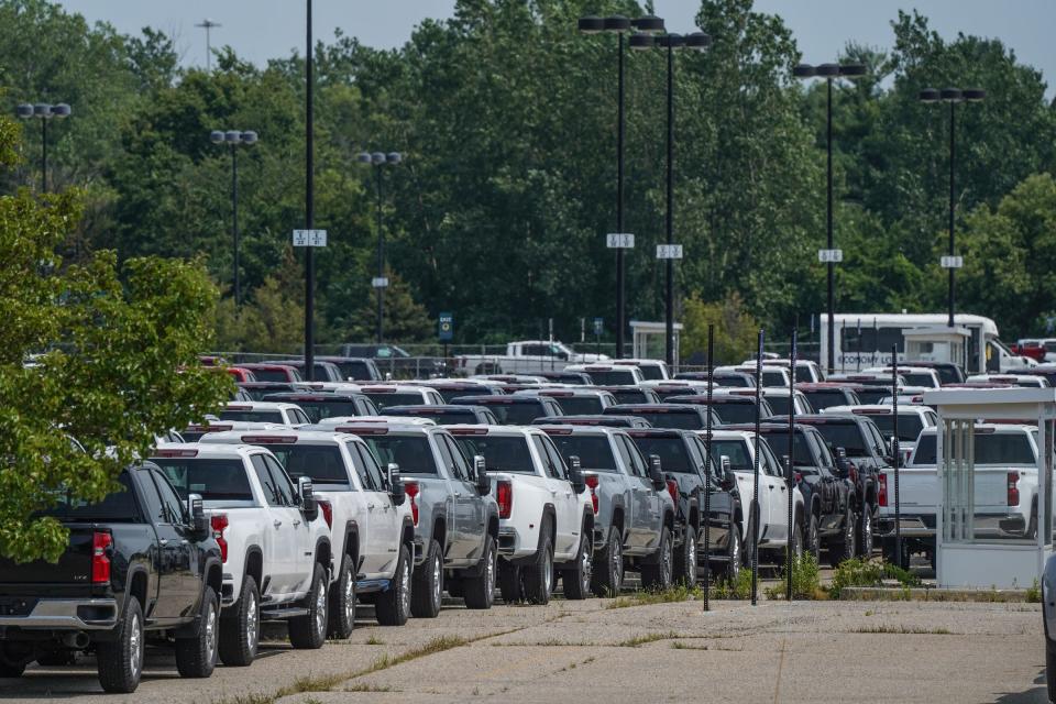 General Motors trucks sit in a gated parking lot next to the Economy Lot across from Bishop International Airport in Flint on August 11, 2021.