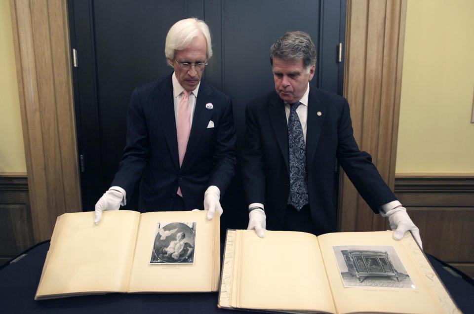 David S. Ferriero, archivist of the United States, right, and Robert M. Edsel, founder and president of Monuments Men Foundation for the Preservation of Art show two newly discovered albums containing photographs of art works and furniture stolen by the Nazis during World War II after they were unveiled at a news conference in the Meadows Museum at SMU in Dallas, Tuesday, Feb. 27, 2012. The Dallas-based Monuments Men Foundation for the Preservation of Art had been contacted by relatives of two World War II soldiers who took the albums from Hitler's home. They'll be donated to the U.S. National Archives. (AP Photo/LM Otero)