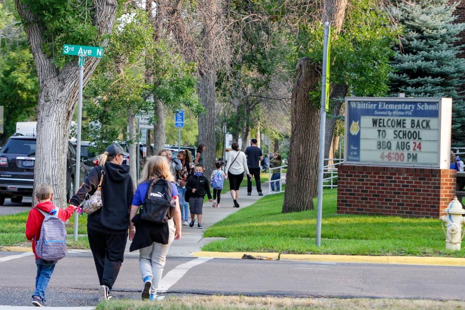 Whittier Elementary School parents and students walk to arrive for the first day of school on Wednesday morning.