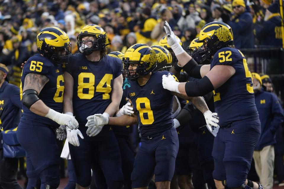 Michigan wide receiver Ronnie Bell (8) celebrates with teammates after making a touchdown catch.