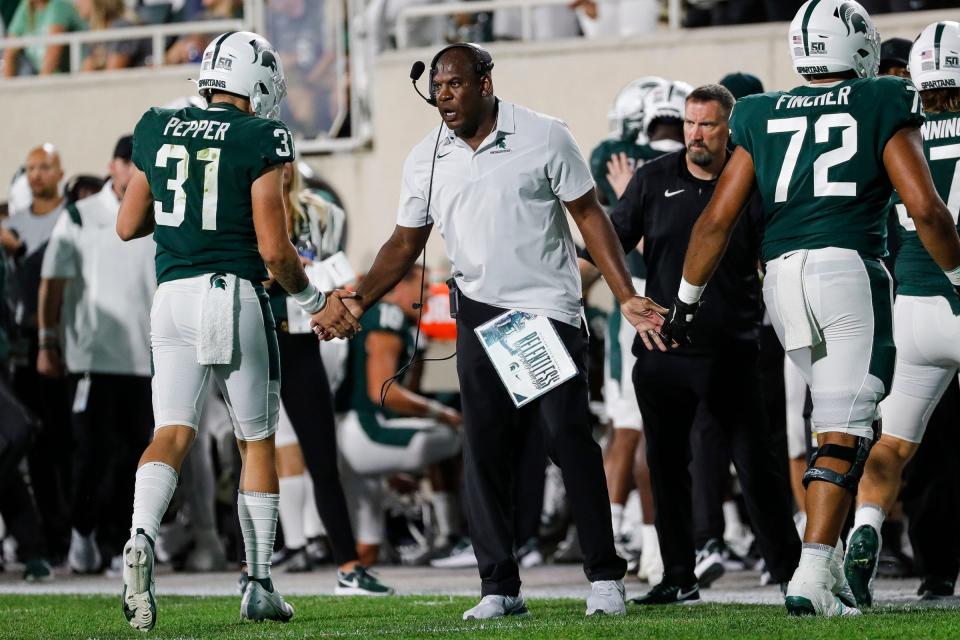 Michigan State head coach Mel Tucker high fives long snapper Hank Pepper (31) during the second half against Western Michigan at Spartan Stadium in East Lansing on Friday, Sept. 2, 2022.