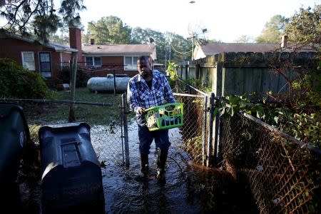 Marquis Sheffield of Herbert Street retrieves clothing from his flooded home after Hurricane Matthew caused severe flooding in Goldsboro, North Carolina, U.S. October 13, 2016. REUTERS/Randall Hill - RTSS3P7