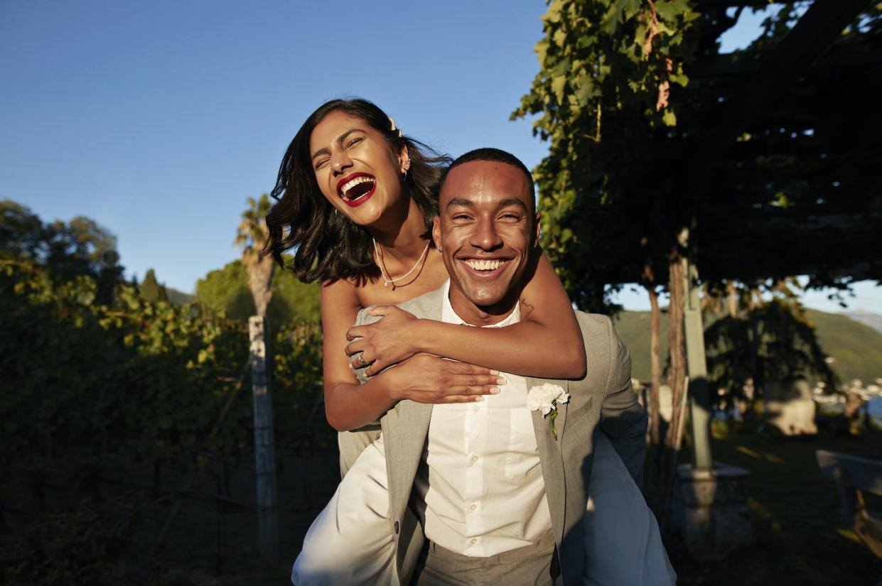 Who did the honors: clergy, a justice of the peace or just a friend? More and more weddings are performed by someone ordained online. <a href="https://www.gettyimages.com/detail/photo/happy-groom-piggybacking-bride-in-vineyard-royalty-free-image/1445187947?phrase=wedding&adppopup=true" rel="nofollow noopener" target="_blank" data-ylk="slk:Klaus Vedfelt/DigitalVision via Getty Images;elm:context_link;itc:0;sec:content-canvas" class="link ">Klaus Vedfelt/DigitalVision via Getty Images</a>