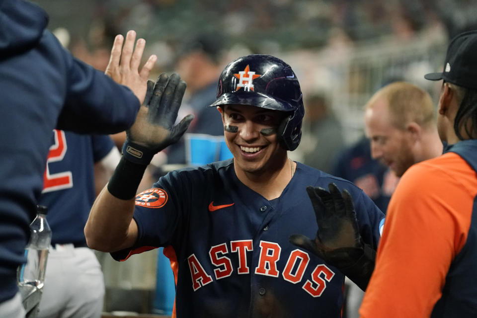 Houston Astros' Mauricio Dubon (14) celebrates in the dugout after scoring in the ninth inning of a baseball game against the Atlanta Braves, Saturday, April 22, 2023, in Atlanta. (AP Photo/Brynn Anderson)