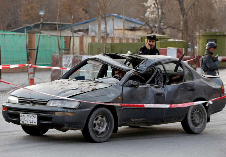 <p>Afghan police keep watch while a man drives his damaged car at the site of a car bomb attack in Kabul, Afghanistan, Jan. 27, 2018. (Photo: Omar Sobhani/Reuters) </p>