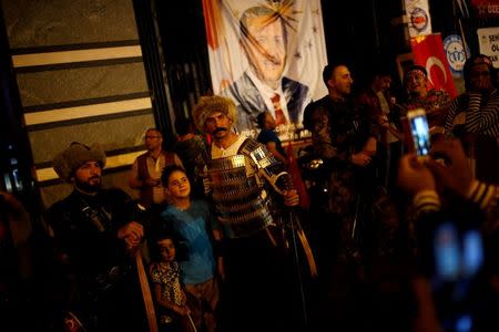 Two men in historical army uniforms pose with people as they gather in solidarity outside Turkish President Tayyip Erdogan's palace night after night since the July 15 coup attempt in Ankara, Turkey, July 27, 2016. REUTERS/Umit Bektas