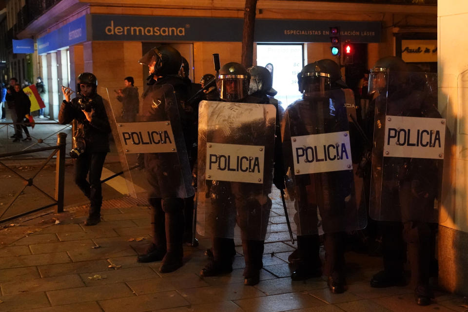 Anti riot police officers try to disperse protesters during a demonstration against the amnesty at the headquarters of Socialist party in Madrid, Spain, Thursday, Nov. 9, 2023. Protests backed by Vox party turned on Thursday night as Spain's Socialists to grant amnesty to Catalan separatists in exchange for support of new government. (AP Photo/Andrea Comas)