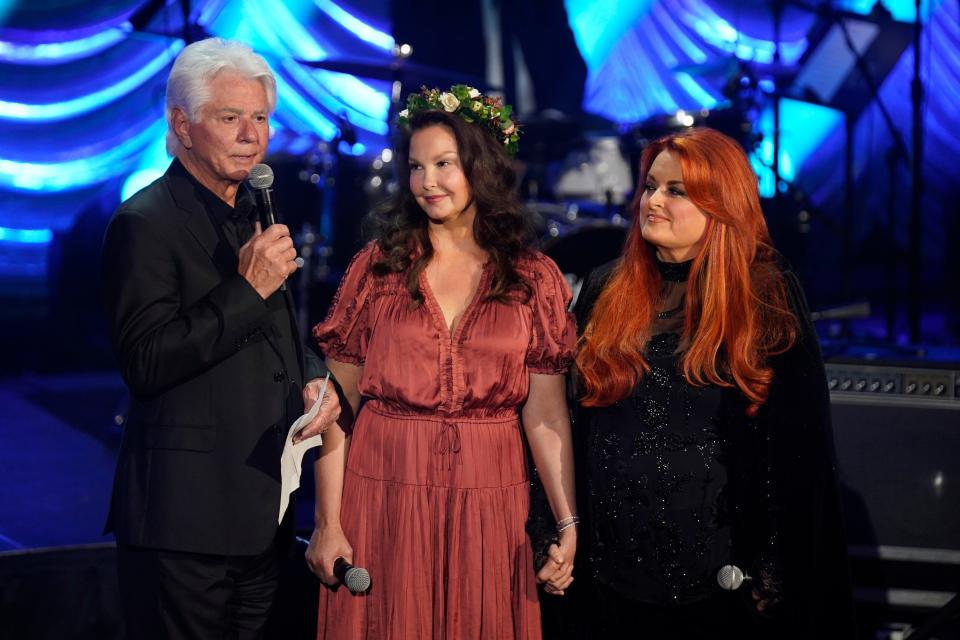 Larry Strickland, Ashley Judd, and Wynonna Judd speak onstage for Naomi Judd's "A River of Time" celebration on May 15.