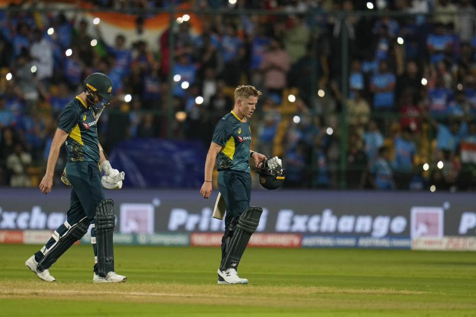 Australia's Nathan Ellis, right, and Jason Behrendorff walks off the field after losing the fifth T20 cricket match and series against India in Bengaluru, India, Sunday, Dec. 3, 2023. (AP Photo/Aijaz Rahi)