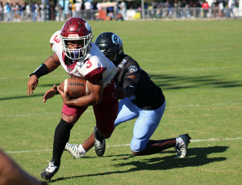 Raines running back Mark Miller (3) sidesteps a tackle by Ribault's Paul Wright (13) during the Northwest Classic.