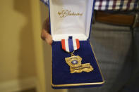 Former Louisiana State Police Trooper Carl Cavalier holds the Medal of Valor he was awarded for an action in New Orleans, at his home in Houma, La. on Friday, Oct. 15, 2021. Cavalier, a Black state trooper who was recently fired in part for criticizing the agency’s handling of brutality cases, says, “If you’re a part of the good ol’ boy system, there’s no wrong you can do. (AP Photo/Allen G. Breed)