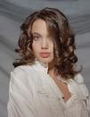 <p>Taking another glam portrait in 1991, this time with bouncy curls and a white blouse.</p>