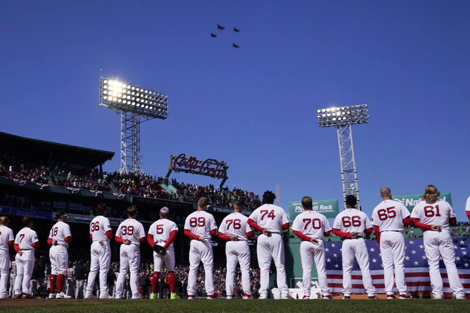 Fighter jets fly over as Boston Red Sox players stand for the national anthem prior to the opening day baseball game against the Baltimore Orioles, Thursday, March 30, 2023, in Boston. (AP Photo/Charles Krupa)